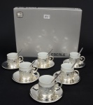 EBERLE - Seis xícaras c/ pires p/ café c/ colheres estilo neoclássico, em metal prateado, recipientes em porcelana branca, s/ uso, na caixa original, total: 18 peças.