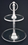 Doceira c/ 02 estágios estilo contemporâneo, em metal prateado c/ pratos em cristal ecológico, med. 26 x 44cm. (metal c/ partes desgastadas).