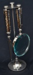 Conjunto indiano de lupa e espatula c/ suporte estilo art deco, em metal espessurado a prata, total 03 peças, alt. 31cm.