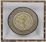 ESCOLA CHINESA - Delicado bordado   em seda chinesa,  PASSARO E FLORES, comumente conhecido como "Xiuhua" (bordando flores, pássaros, pavilhões e paisagens). Etiqueta de procedência no verso. Medindo 26,5 cm diâmetro.  Com moldura de madeira com pátina em folha de ouro e vidro,  no formato de bambu,  medindo 39,5x39,5 cm.