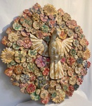 Belíssimo Medalhão representando divino Espírito Santo Esculpido em madeira, ricamente trabalhado, contornado por flores, conjunto montado em rodas de madeiras e peças transversais. Medidas; 84 cm de Diâmetro.