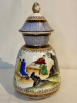 Potiche Chinês em porcelana com exuberante pintura de cenas orientais. Possui bicado na boca do vaso. Med: 29cm de altura com tampa x 9,cm diâmetro.
