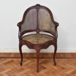 Elegante e antiga cadeira de braços em jacarandá, no estilo Luiz XV, saia, braços e parte central do