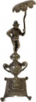 Elegante e antigo paliteiro em metal espessurado a prata representando figura masculina com guarda chuva sobre ânfora. Med. 18 cm.