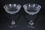 BACCARAT - Par de taças para champanhe em cristal translucido de famosa manufatura francesa, modelo "NANCY", marca da manufatura no fundo, haste cilíndrica e base circular. med: 11,5 cm
