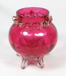 Vaso floreira em vidro veneziano na cor rubi, gargalo sobreposto por linha translucida curva em relevo, suspenso por pés curvos translúcidos. med: 12,5 cm