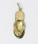 Pingente em ouro no teor 18 kl, formato de sandália baixa cravejada de brilhantes. med: 2,5 cm, PT: 1,5 gramas