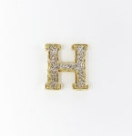 Pingente no formato da letra "H" em ouro e ouro branco, teor 18 kl. med: 2 cm x 1,5 cm, PT: 2 gramas
