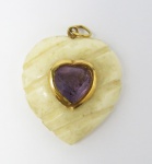 Pingente no formato de coração em marfim esculpido, encrustado com ametista ao centro e aplicação a ouro. med: 4 cm x 3 cm, PT: 8 gramas
