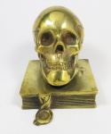 H. TRULI - Crânio sobre livro, alegoria a ciência, cerre livre em bronze polido. med: 12 cm x 8 cm x 8 cm