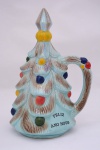 Pinheiro de natal em louça com bolas coloridas e alça. Inscrição de "Feliz Ano Novo".  Altura 28 cm.