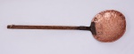 Antiga escumadeira em cobre. Cabo de madeira, cravado na pá com reforço. Pá redonda, medindo 28 cm. Comprimento total 88 cm. Marcas de uso.