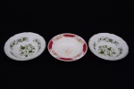 Três covilhetes em porcelana: sendo dois com decoração de ramagens na cor verde sobre fundo branco, e um com decoração em barras vermelhas e flores sobre fundo branco. Diâmetro 14,5 cm.