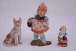 Três bibelôs em biscuit policromado representando crianças e cachorro. Todos marcados Japan. Alturas 14, 10 e 7 cm.
