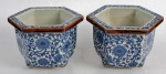 Par de pequenos cachepots em cerâmica azul e branca, formato sextavado, decorada com motivo de flores e arabescos. Altura 10 x diâmetro 14 cm.