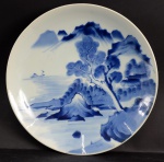 Medalhão em porcelana japonesa azul e branco, decoração com motivo de paisagem. Diâmetro 35 cm.