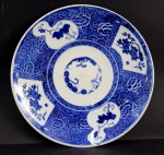 Medalhão em porcelana chinesa azul e branco, decoração com motivo de flores. Diâmetro 38,5 cm.