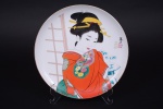 Prato em porcelana oriental, decorado com pintura de gueixa, marcado e assinado, Diam. 26 cm.
