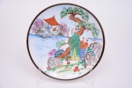 Prato em porcelana oriental, borda em douração, decorado com pinturas de paissagens, sábio, gueixa, flores e folhagens. Diam. 23,5 cm.