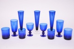 Conjunto de copos e taças em vidro colorido na cor azul, contendo: 11 taças para água, 6 copos para whisque, 6 copos para drinques, 2 taças para vinho e 3 flutes. Altura 16cm; 9,5 cm; 9cm; 12 cm; 23 cm. Total de peças 28.  (Um copo de whisque com bicado e uma taça para vinho com bicado).