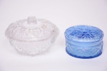 Duas peças: A) Bobonier em cristal translúcido, decorado com lapidações, marcado ao fundo, Medindo 9,5 x 13 cm; B) Porta jóias em cristal na cor azul decorado com lapidações, medindo 5,5 x 9,9 cm.