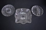 Conjunto composto de 3 porta aperitivos em cristal translúcido todos cinzelados. Déc 40. Med: maior: 5 x 17 cm. menor: 13 x 13 cm.