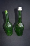 Duas antigas garrafas em vidro na cor verde com detalhe floral. Med; 29 cm sem tampa  31 cm com tampa.