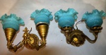 Par de apliques em metal dourado e cinzelado, com as cúpulas em formato de flor. Com patina azul. Década de 50. Med: 17 x 24 cm. e 20 x 17 x 24 cm.