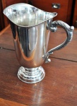 Lote composto de 01 bela jarra d'água em metal espessurado a prata com belo trabalho cinzelado, mede: 0,25cm de alt., 0,16cm de diãmetro