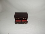Caixa porta joias em forma de cômoda confeccionada em baquelite na cor vermelha com caixa de musica com 4 gavetinhas com puxadores dourados. Med.: 12x12x21 cm.