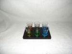 Conjunto de copinhos para licor em vidro nas cores azul, amarelo, verde , âmbar e roxo.acompanha base em madeira.
