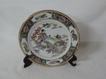 MANDARIM - Lindo prato de coleção em porcelana oriental na cor branca decorada com figuras, flores, insetos e folhagens e borda filetada a ouro. Med.: 26 cm.