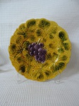 SERRAGUEMINES - Lindo prato de coleção em faiança francesa decorada com folhas e cacho de uvas na galeria central. Peca marcada na base. Med.: 19 cm.