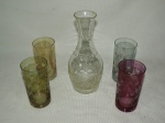 Lote constando cinco peças em demi cristal sendo um decanter e quatro copos coloridos.