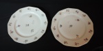 Par de pratos rasos em porcelana francesa na cor branca decorada com flores e borda filetada a ouro, Peça marcada na base.Med.: 23 cm.
