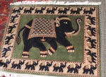 Antigo tapete feito a maquina nas cores verde e marrom decorada com elefante árabes. Med.: